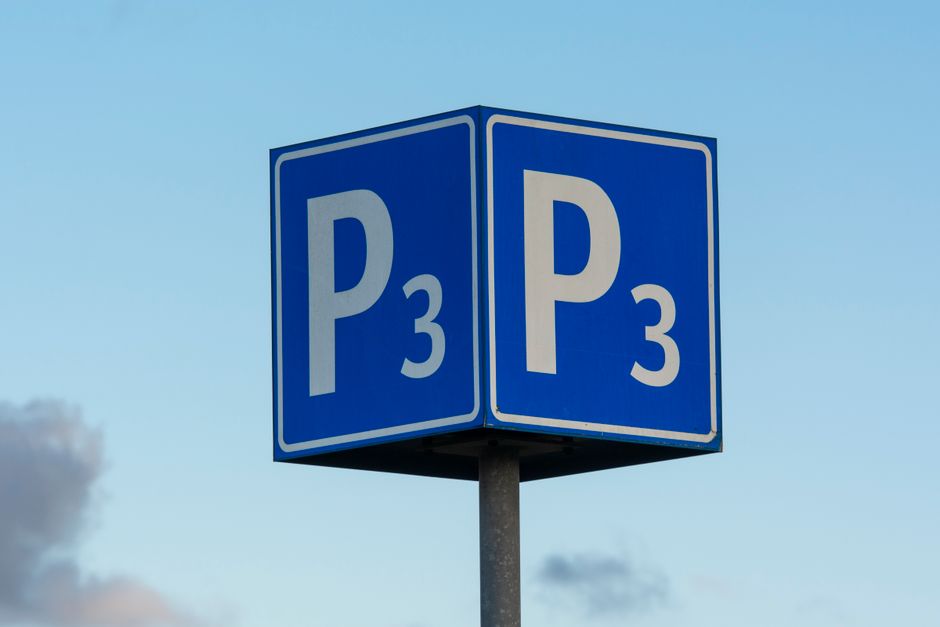 A close-up view of a large blue parking sign with two faces, each displaying a white letter 'P' followed by the number '3' in white, indicating designated parking zones. The sign is mounted on a metal